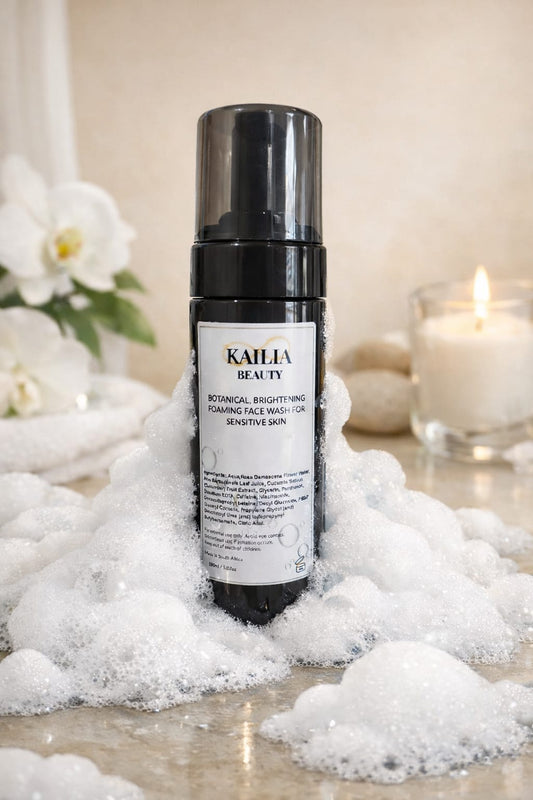Kailia Beauty foaming face wash bottle on a surface with bubbles and decorative elements.